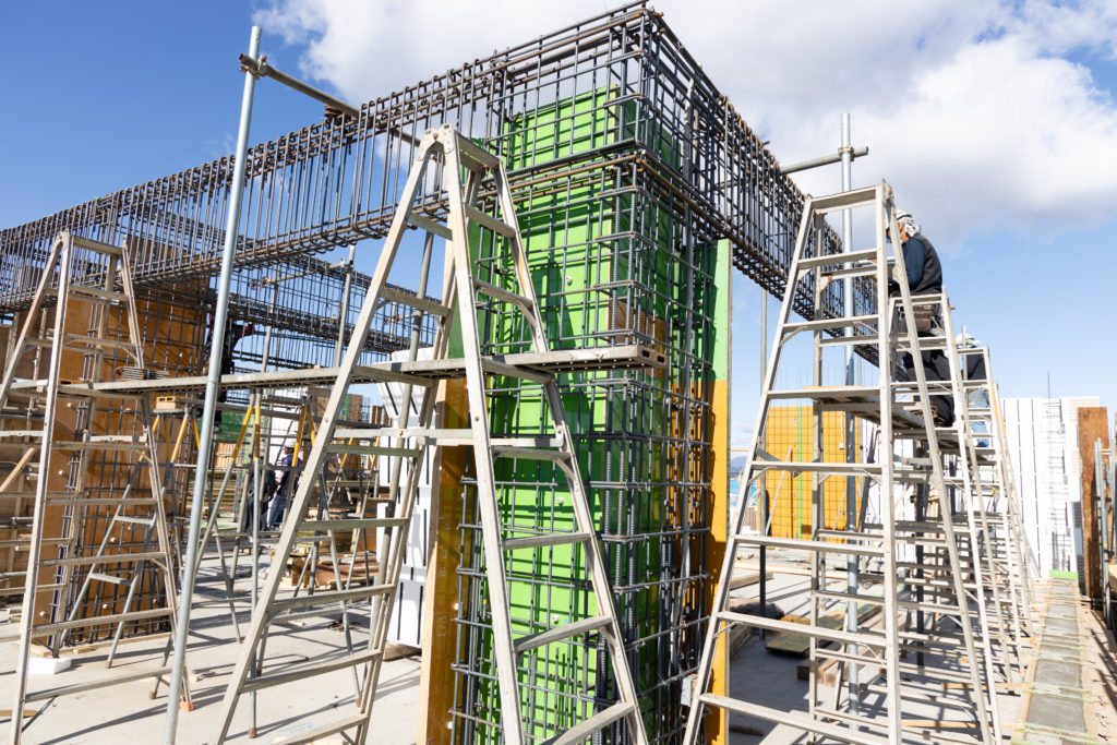 梁の配筋と柱型枠が建て込まれた建設現場